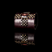 Garnet-toned crystal and beaded cross on deep-plum leather cuff against a black background