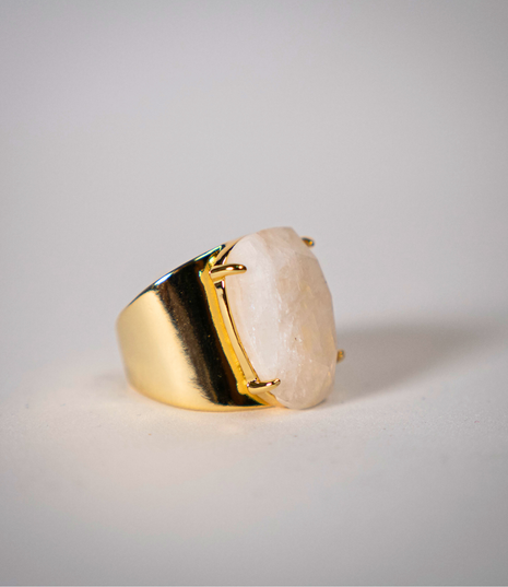 Gold ring with a large stone on a light gray background