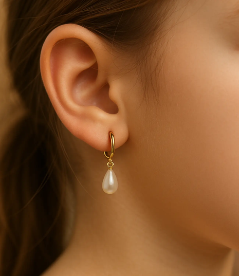 Close-up of an ear wearing a gold earring with a pearl drop.