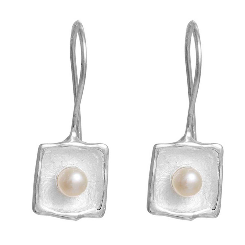 Pair of silver earrings with pearl centers on a white background