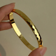 ENOTIA faceted gold-plated stainless steel bangle – high shine finish