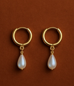 Gold hoop earrings with pearl drops on a brown background, branded 'Phoebe's'.