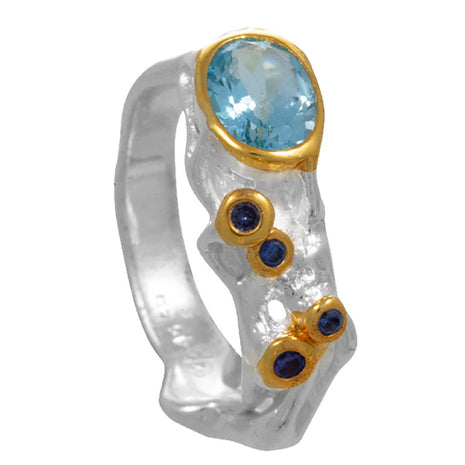 Silver and gold ring with blue gemstones on a white background