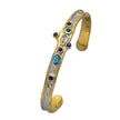 Gold and silver bracelet with blue gemstones on a white background